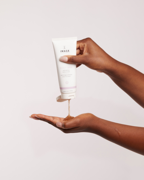 A woman is pouring IMAGE BODY SPA exfoliating body scrub