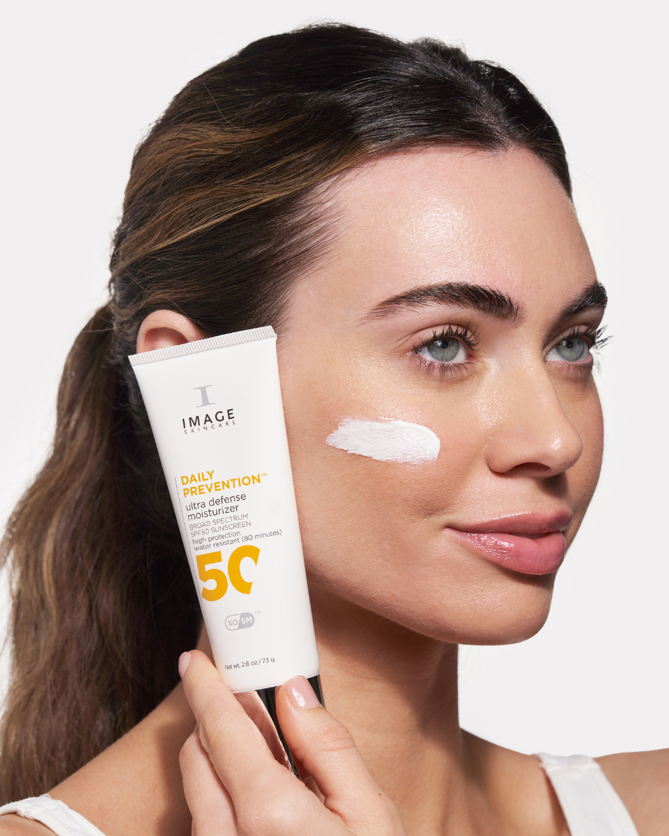 Girl holding Image Skincare DAILY PREVENTION Ultra Defense Moisturizer