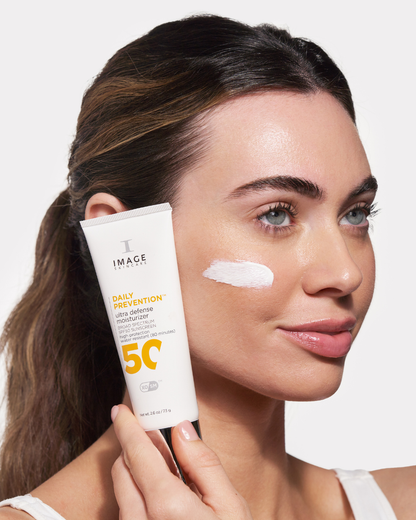 Girl holding Image Skincare DAILY PREVENTION Ultra Defense Moisturizer 