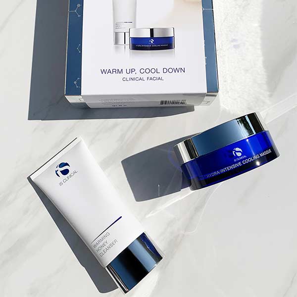 Luxury jar of iS Clinical Warming Honey Cleanser beside tub of Hydra-Intensive Cooling Masque